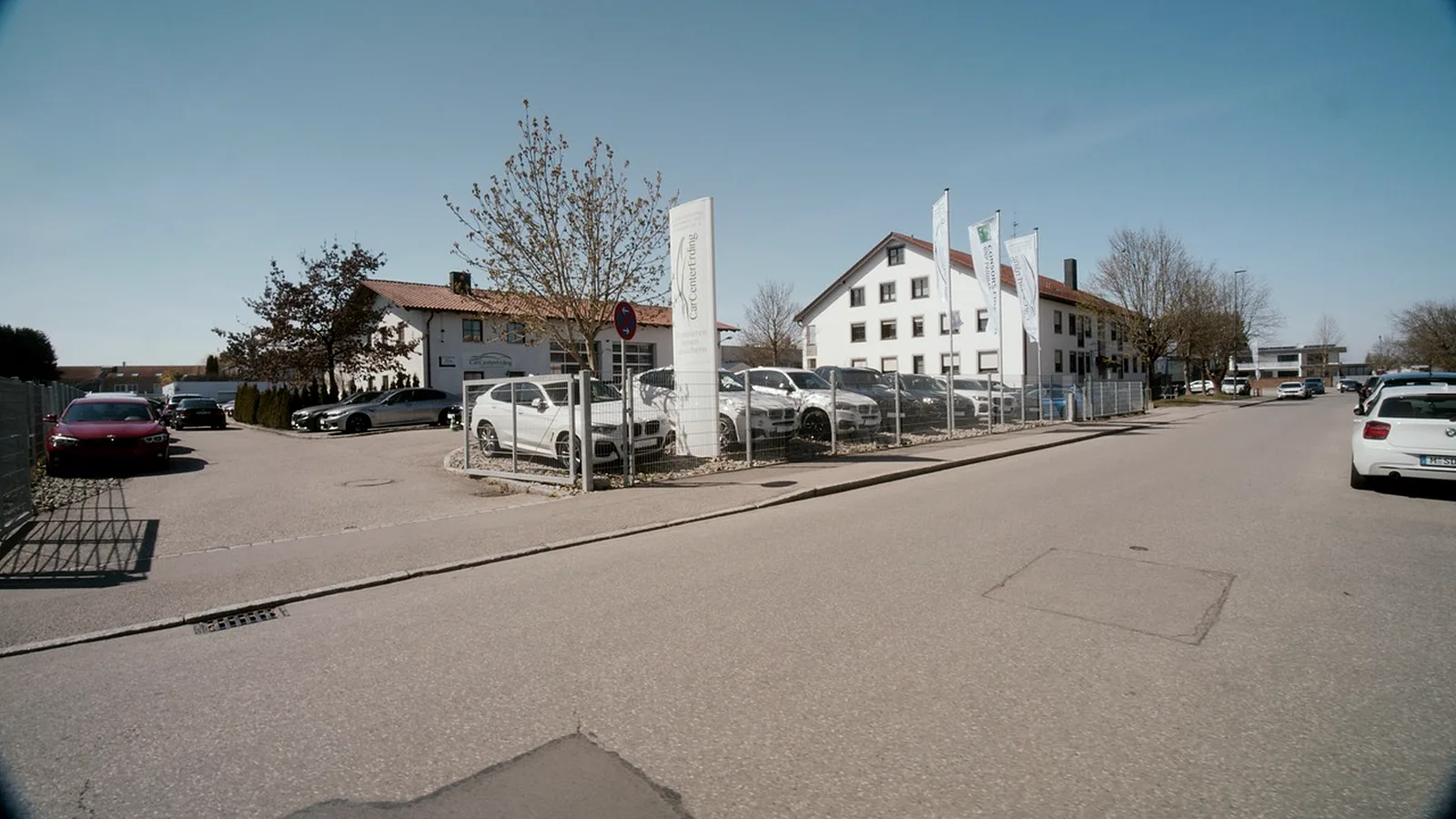 Otto-Hahn-Straße vor CarCenter Erding mit Pylon und Logo-Fahnen