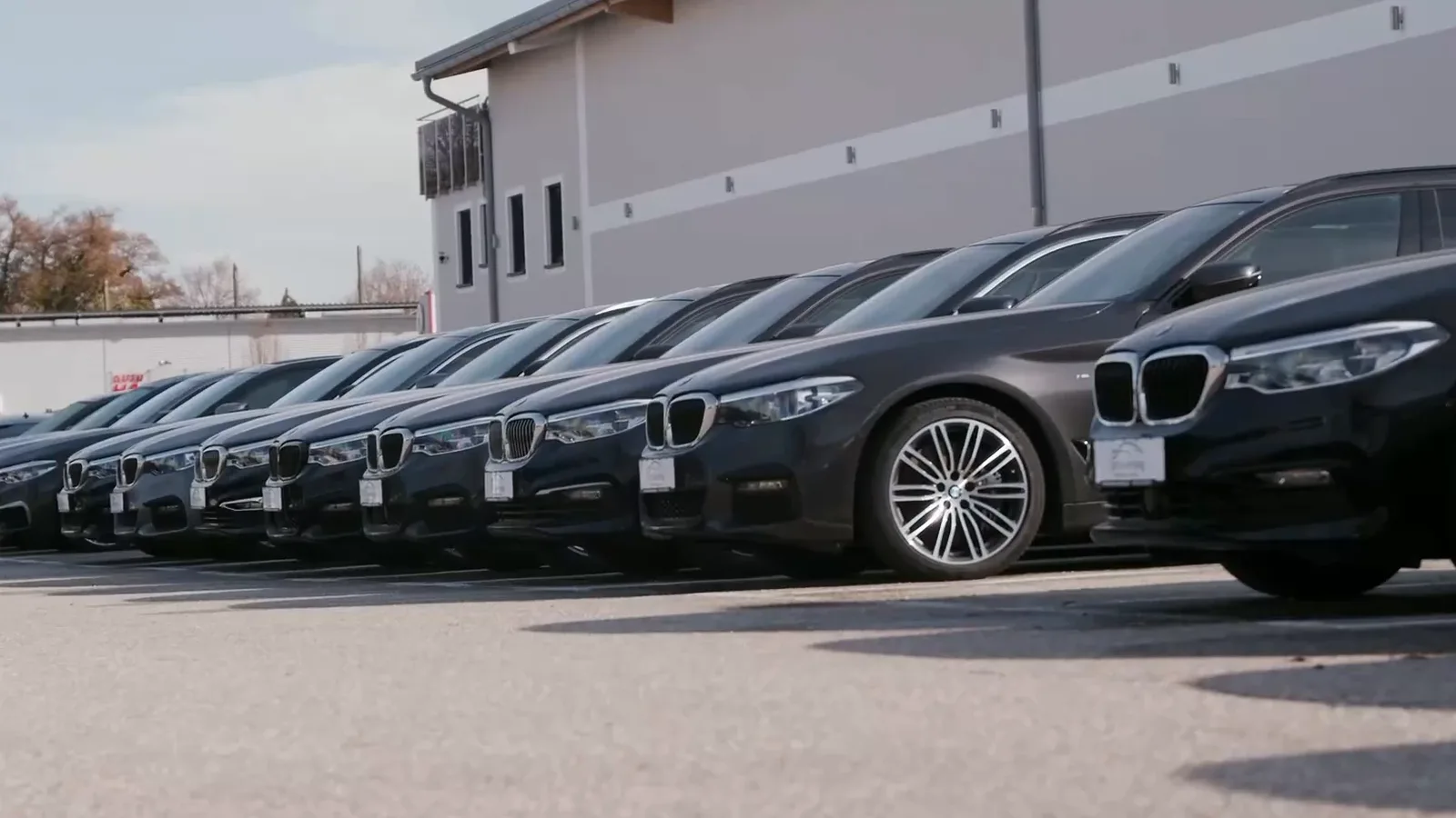 Blick über eine BMW-Motorhaube auf den Hof in Erding mit den Fahrzeugreihen