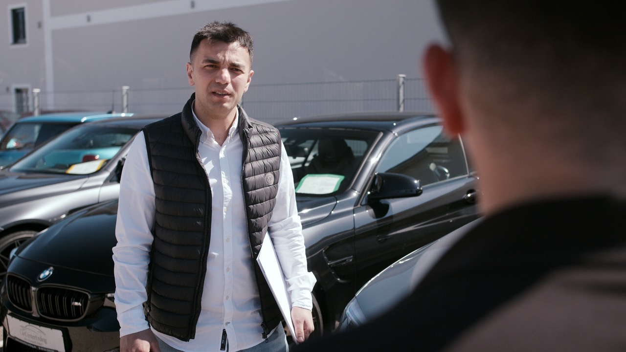 Khalil A. Rahman auf dem Hof des CarCenter Erding im Gespräch mit einem Kunden